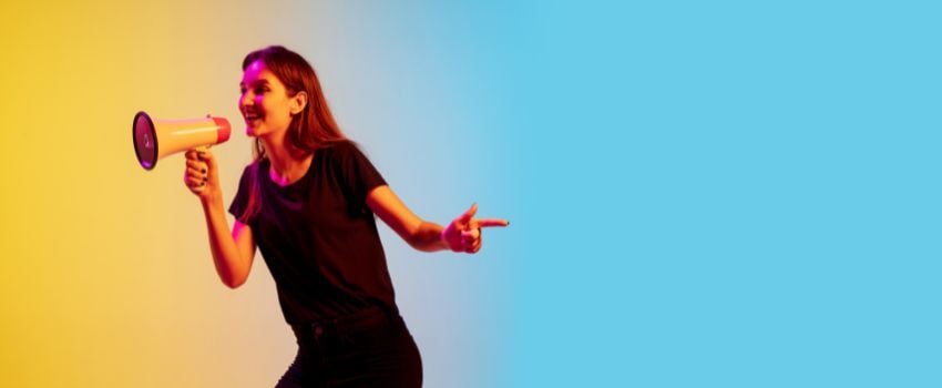 Persona con megáfono protagonizando un anuncio publicitario, encontrando la forma de hacer anuncios publicitarios exitosos