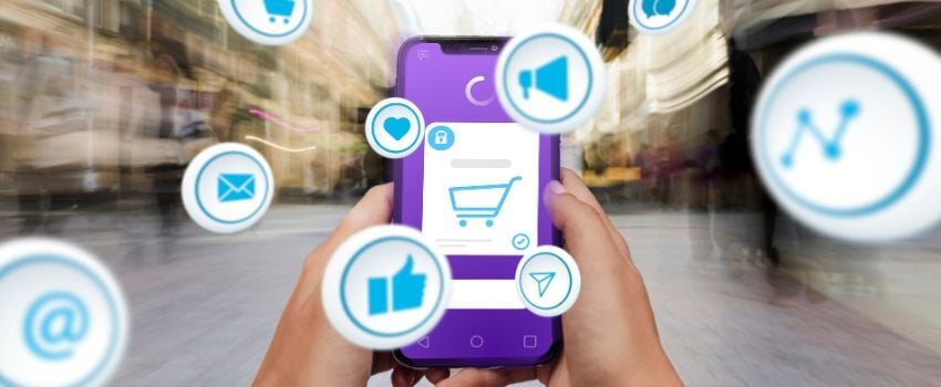 Manos manipulando un celular haciendo campaña de e-commerce marketing para un comercio electrónico o tienda en línea, atrayendo conversación, awareness y ventas