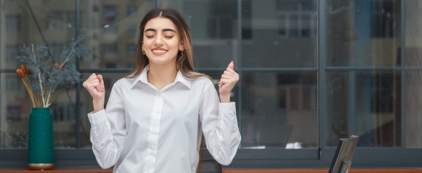 Joven mujer sonriendo en la oficina tras lograr el equilibrio entre trabajo y vida personal