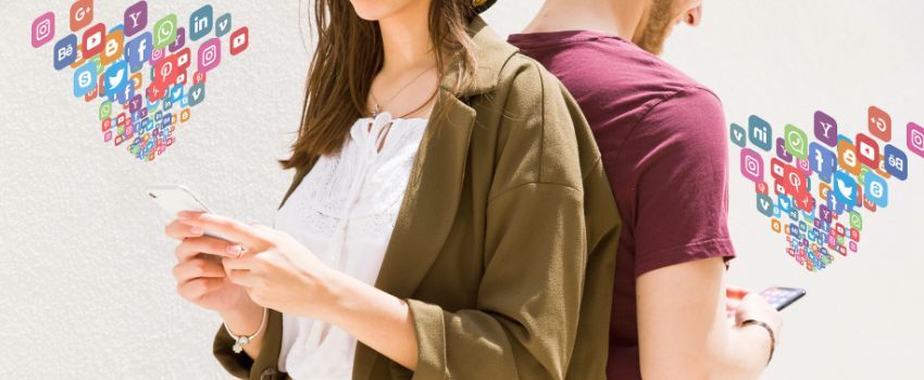 Pareja ejemplificando el liquid marketing y aprovechando la marca ágil, parados espalda con espalda, consultando e interactuando en redes sociales