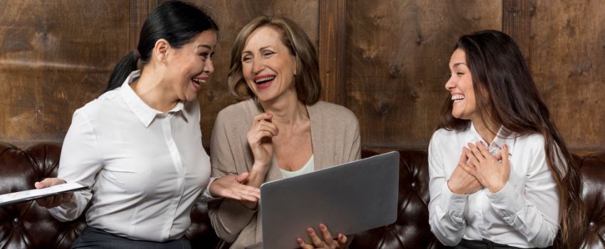 Mujeres profesionistas exitosas conversando y riendo entre sí, aludiendo a una imagen de anuncio de publicidad de mujeres sin estereotipos