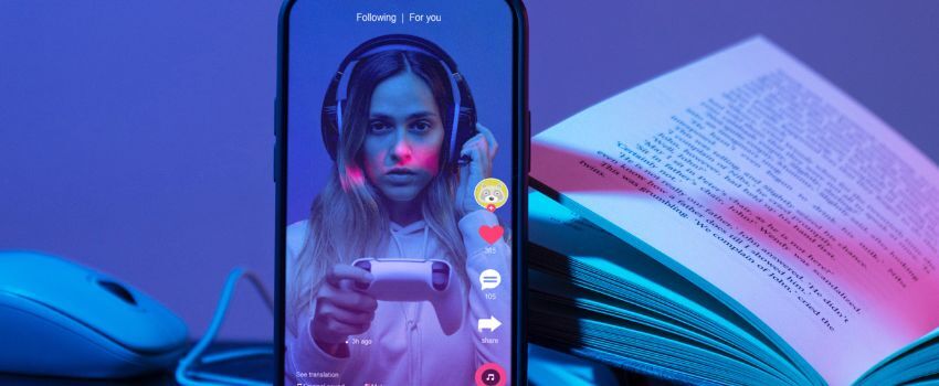 Dispositivo móvil muestra en pantalla a persona jugando videojuegos en vivo en TikTok, mientras se despliegan TikTok Search Ads