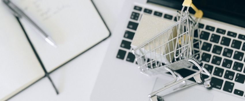 Carrito de compras y laptop representando la necesidad del aumento de tráfico y ventas para el éxito de una tienda online